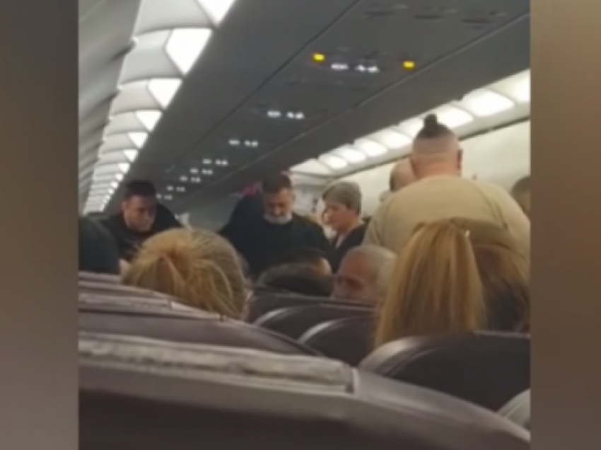 Një burrë tenton të hapë derën e avionit dhe të hidhet