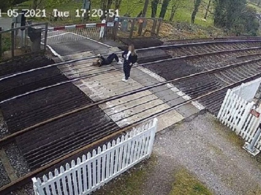 ​Çudia në Britani, vajza qëndron e shtrirë me telefonin në dorë në shinat e trenit